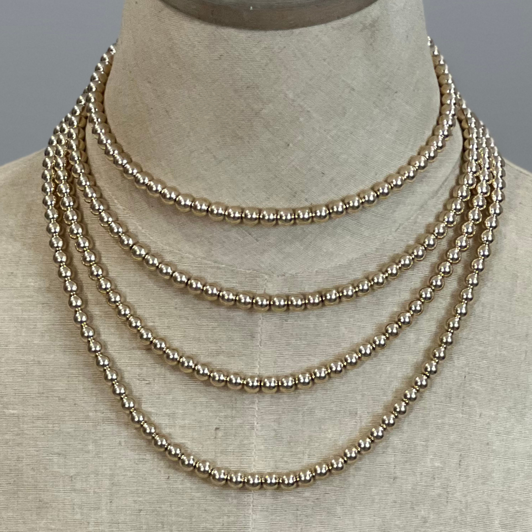 Gold beaded necklace on a mannequin neck