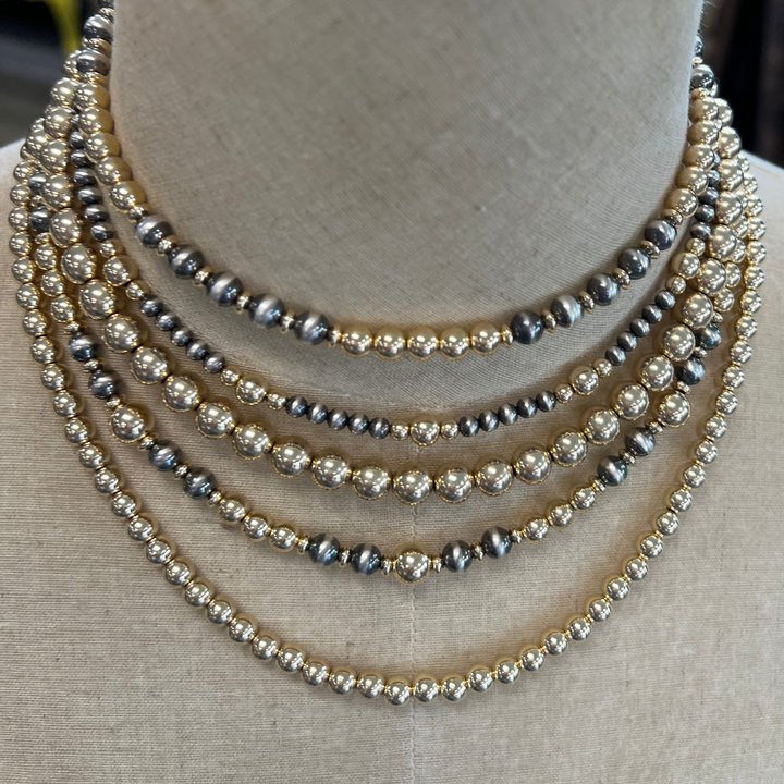 Multiple Gold and silver pearl necklaces on a mannequin bust