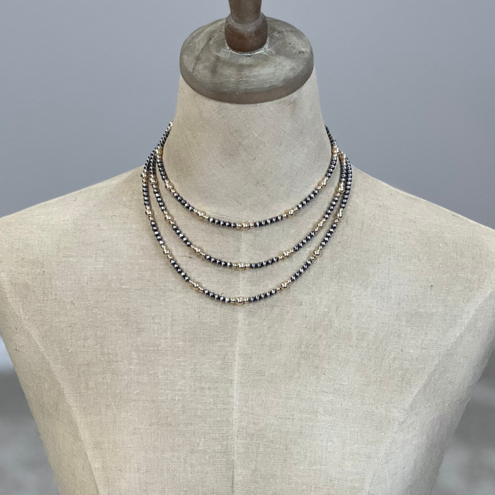 Gold and silver Necklaces on a mannequin with a gray background