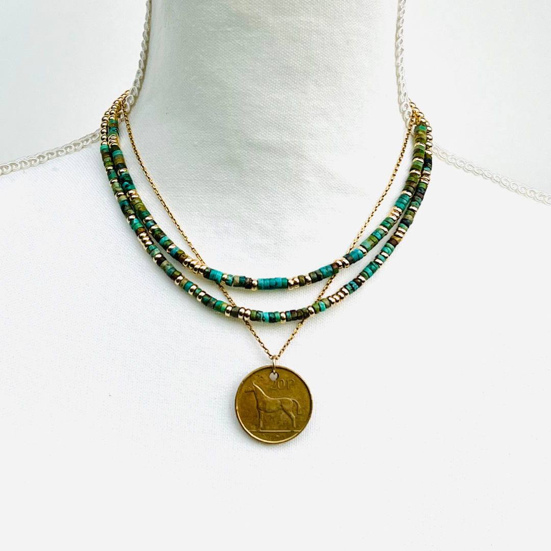 Necklace with Turquoise and gold beads on a white background with  horse pendant